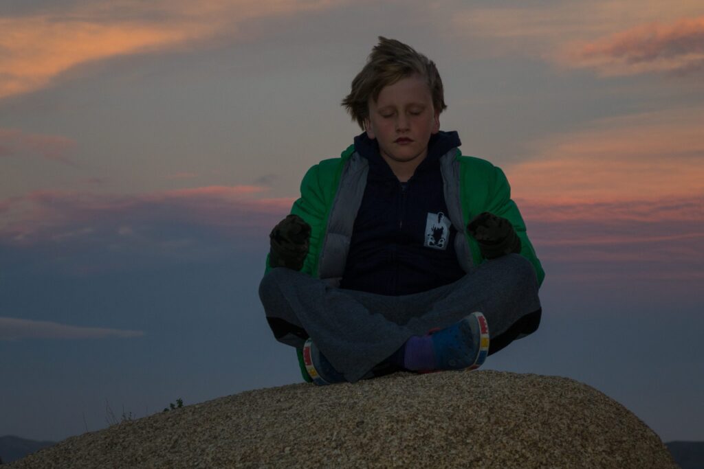 Child meditating on mountain top lessons from Internal Retreat